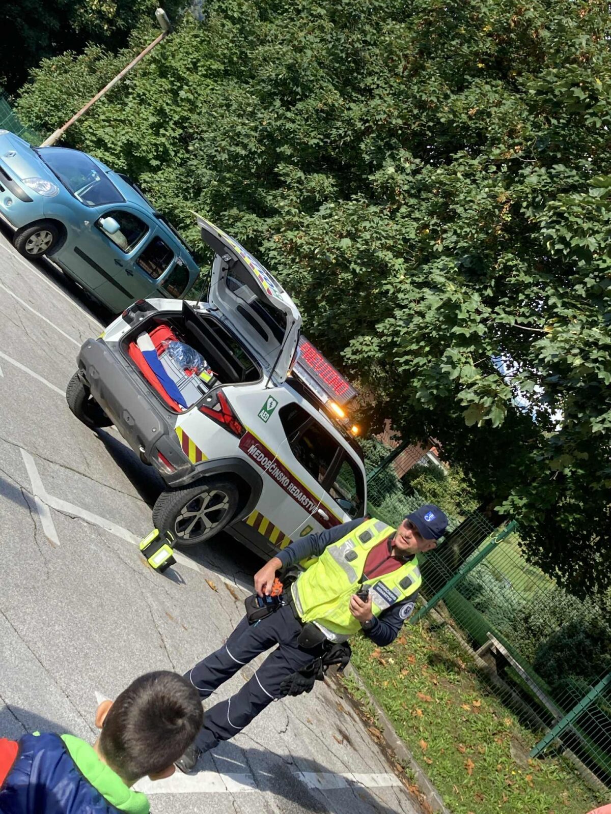 Obisk občinskega redarja v tednu mobilnosti – predstavitev poklica in pripomočkov na parkirišču vrtca