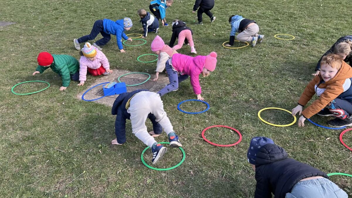 Otroci izvajajo gibalno nalogo na travniku