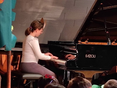 Glasbena pravljica v glasbeni šoli – deklica igra na klavir