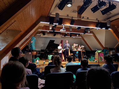 Glasbena pravljica v glasbeni šoli – igralci na trobente, v ospredju otroci